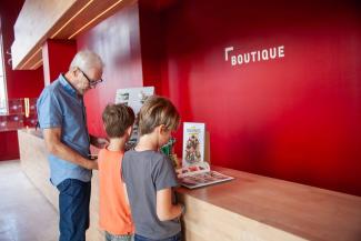 Visiteurs consultant des ouvrages et souvenirs dans la boutique du Musée de la Résistance et de la Déportation de l’Aisne