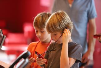 Visiteurs utilisant un audioguide lors de la visite du Musée de la Résistance et de la Déportation de l’Aisne