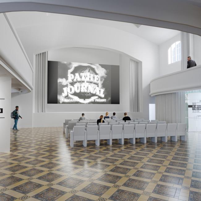 Salle de projection du musée avec écran allumé et visiteurs assis.