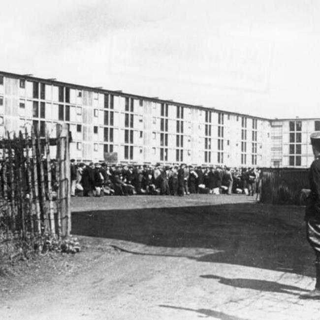 Vue du camp de Drancy avec un groupe de personnes rassemblées sous la surveillance d’un garde