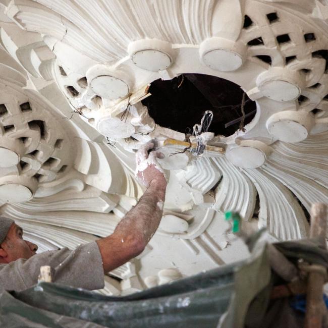 Artisan staffeur restaurant une rosace décorative au plafond du musée de la Résistance et de la Déportation de l’Aisne