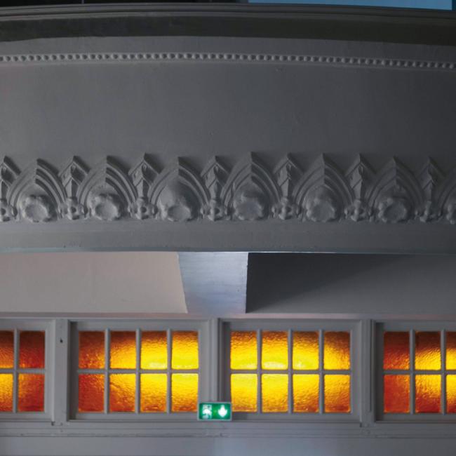 Moulures restaurées sur la galerie intérieure du musée de la Résistance et de la Déportation de l’Aisne au-dessus des verrières colorées