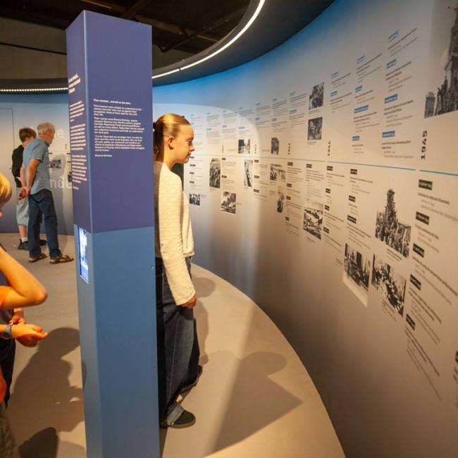 Visiteurs découvrant la chronologie de la Seconde Guerre mondiale dans le parcours de l’exposition permanente du Musée de la Résistance et de la Déportation de l’Aisne